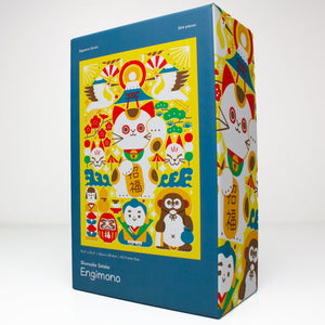 Engimono Japanese-themed jigsaw puzzle box featuring colorful cartoon characters and traditional motifs on a blue background, photographed on a clean white studio background.