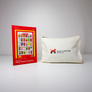 An off-white canvas pouch with a red and black 'GOOD FORTUNE MAKE MONEY' logo sits next to a red and yellow 'Make Happy Company' brochure on a light gray background.