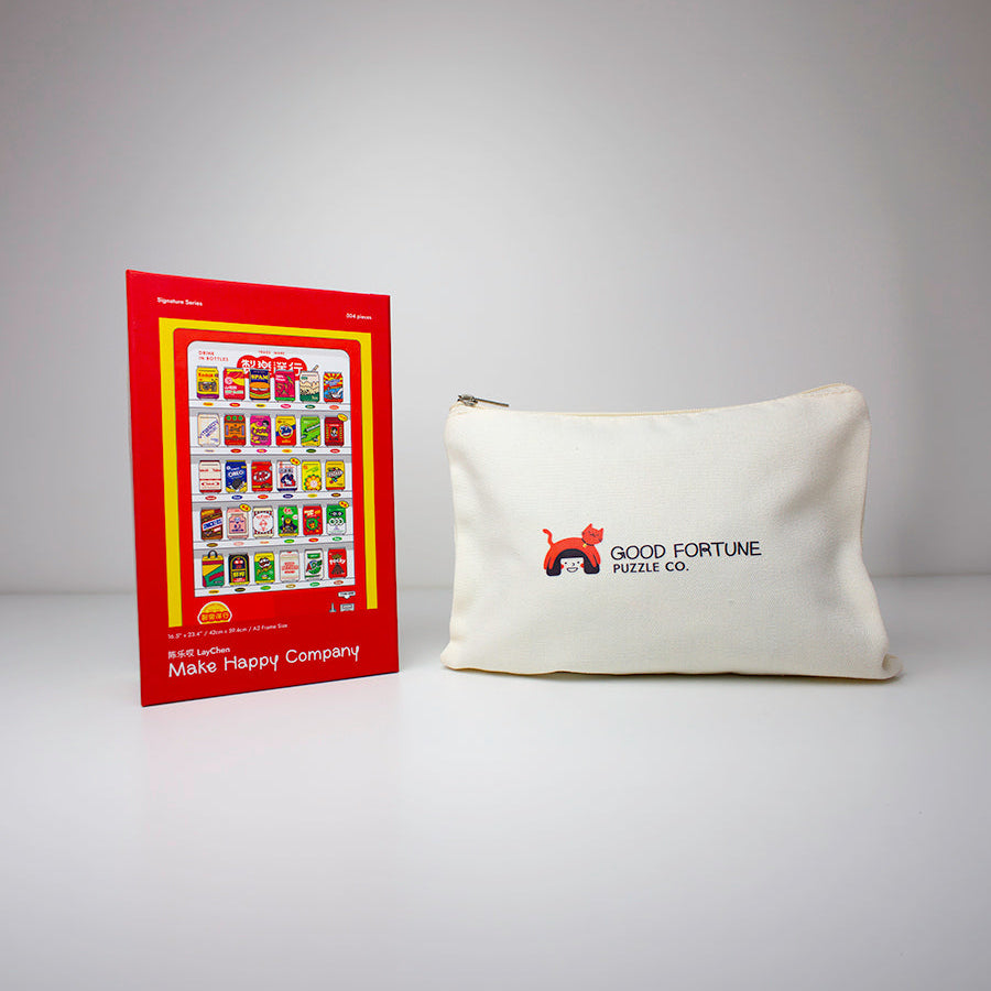 An off-white canvas pouch with a red and black 'GOOD FORTUNE MAKE MONEY' logo sits next to a red and yellow 'Make Happy Company' brochure on a light gray background.